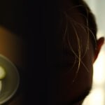 A worried person examining their hair, questioning if the keto diet causes hair loss.